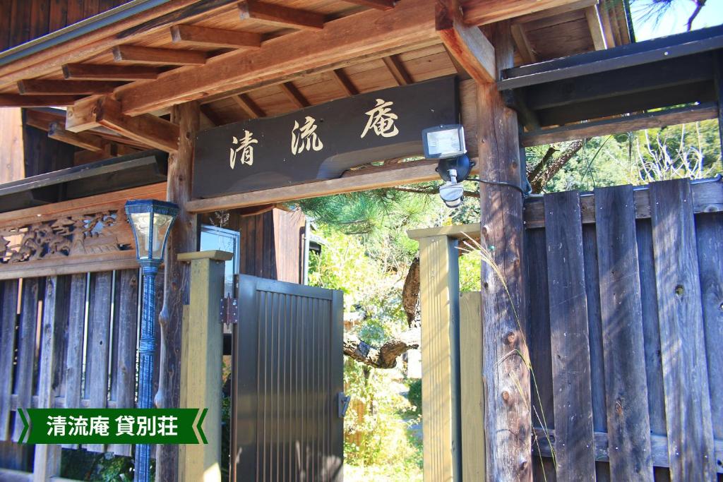 an entrance to a wooden building with writing on it at まんのう清流庵 in Manno