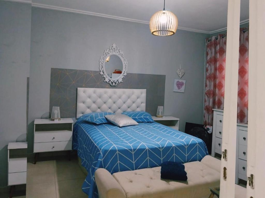 - une chambre avec un lit bleu et un miroir dans l'établissement PdLuz Casa Completo e Confortável, à São Paulo