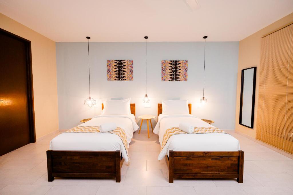 a bedroom with two beds and a table at Rebungan Resort Langkawi in Kuah