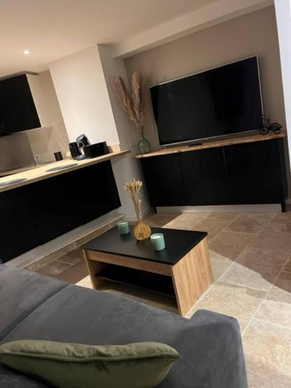 - un salon avec un canapé et une télévision à grand écran dans l'établissement Studio Cocoon, à Saint-Martin