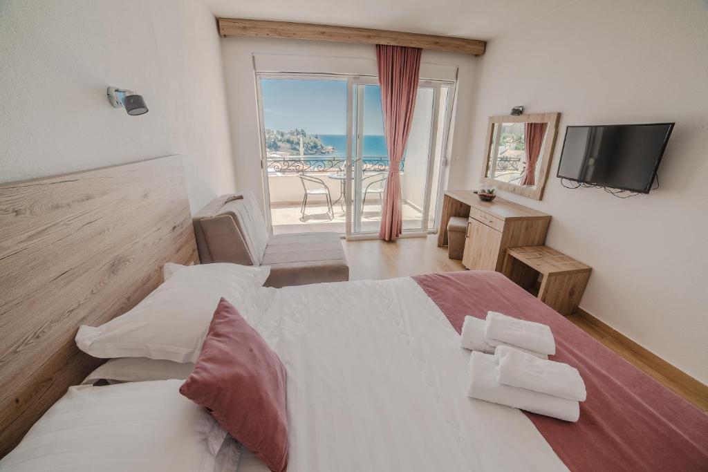a bedroom with a bed and a view of the ocean at Hotel NOBEL Ulcinj in Ulcinj