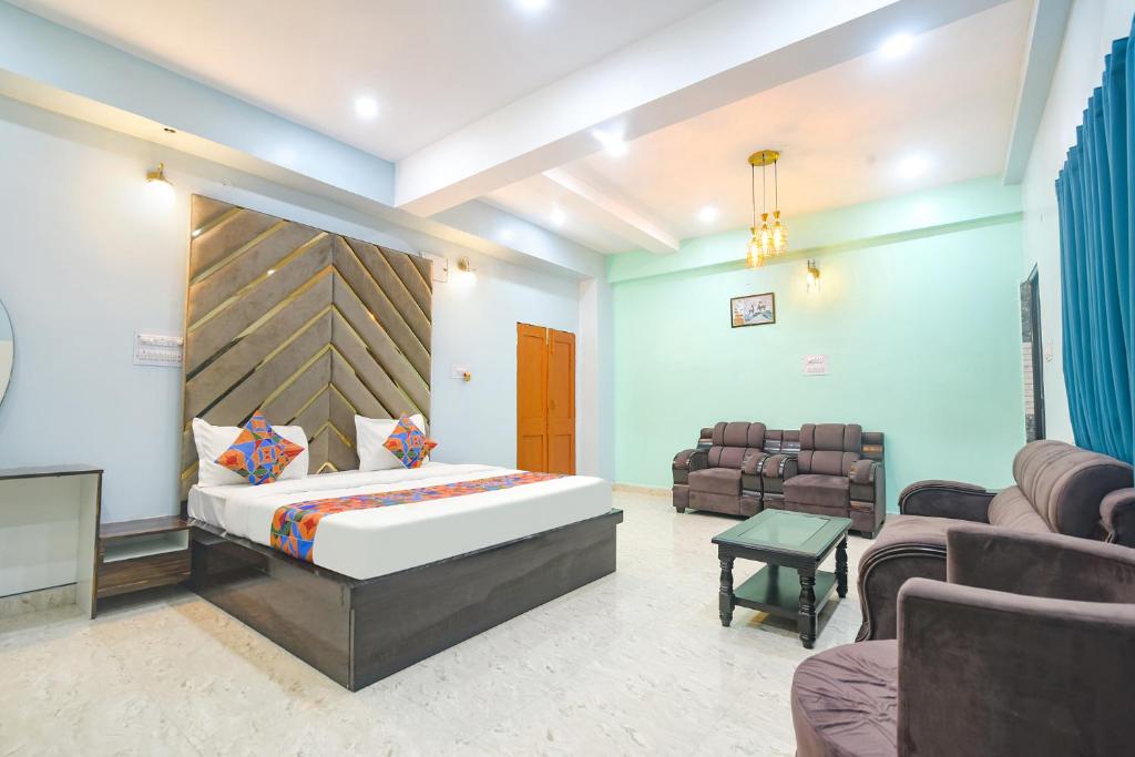a bedroom with a bed and a couch and chairs at FabExpress MU Club in Patna