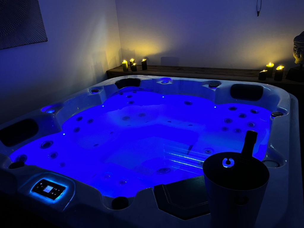 a blue hot tub in a room with lights at Détente & Spa in Villers-Allerand