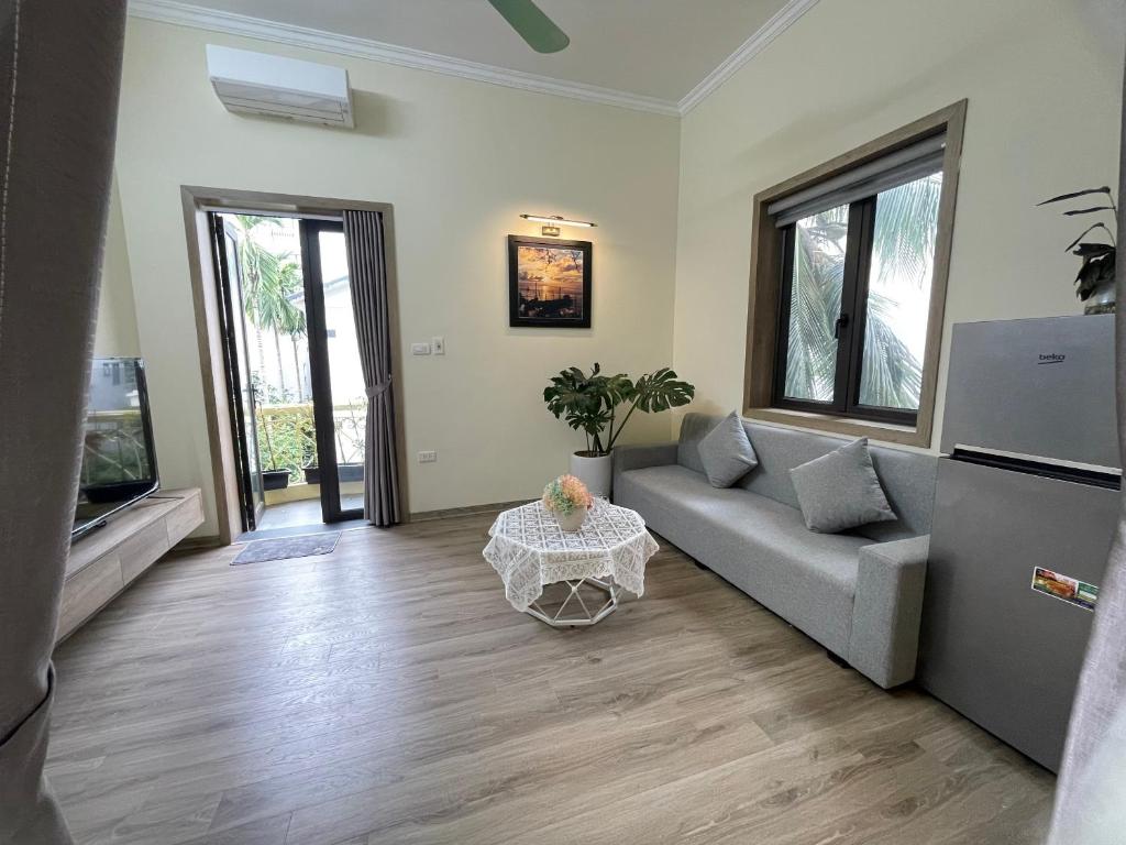 uma sala de estar com um sofá e uma mesa em Happy House 301 1bed1room 40m2,Balcony,near Ho Tay Lake em Hanói