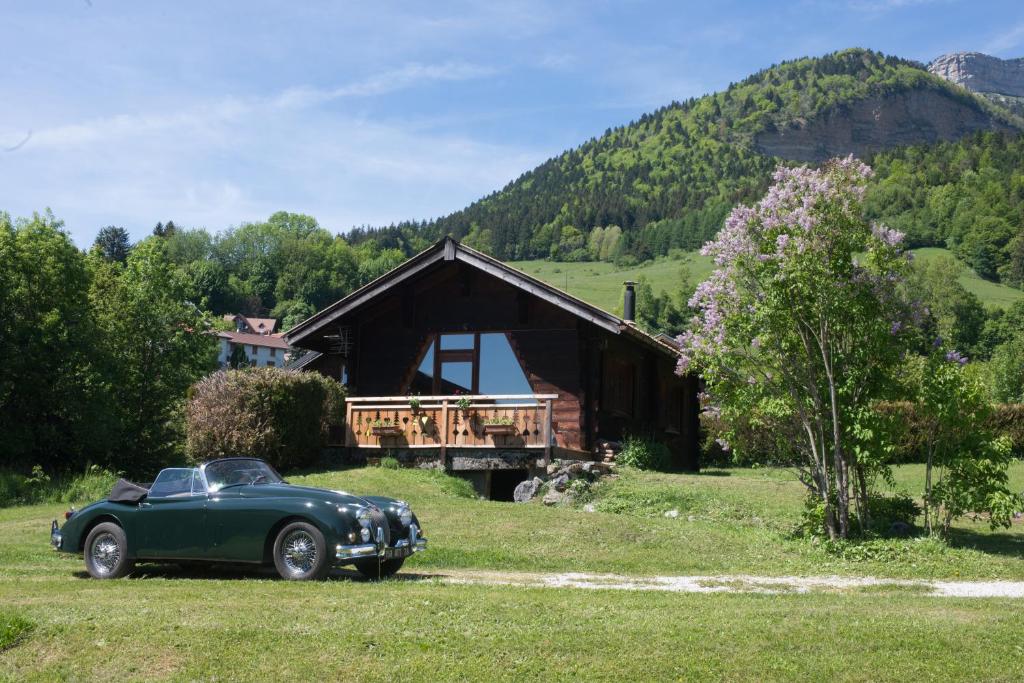 ein grünes Auto, das vor einer Hütte parkt in der Unterkunft Le Petit Skieur B&B in Le Sappey-en-Chartreuse