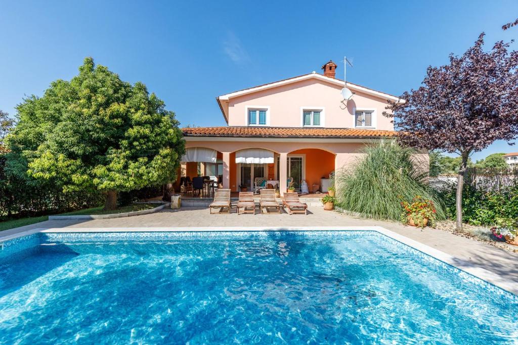 eine Villa mit einem Pool vor einem Haus in der Unterkunft Villa Brioni 1 in Pula