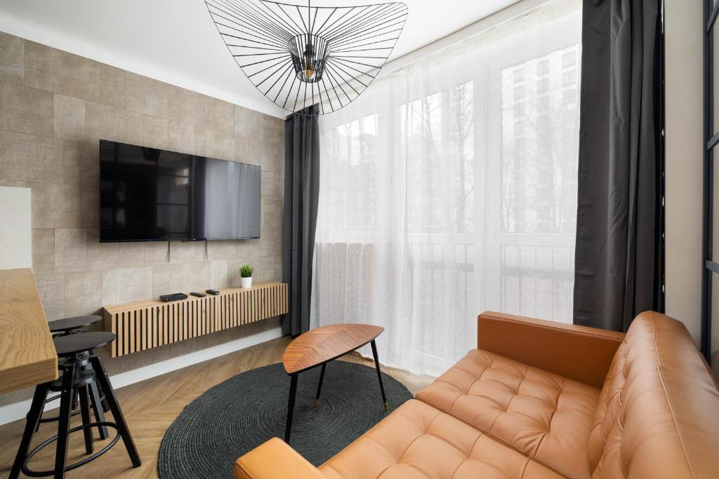ein Wohnzimmer mit einem Sofa und einem TV in der Unterkunft City Center Apartment near Park Saski by ECRU in Warsaw WWA63 in Warschau