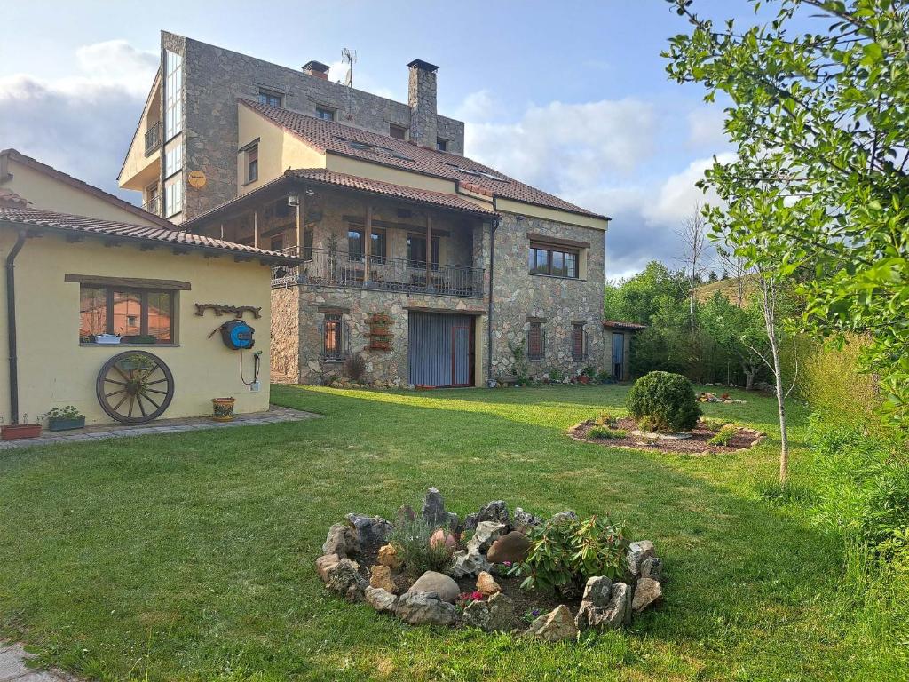 una grande casa in pietra con giardino nel cortile di Hotel Rural Valle del Tuejar a Taranilla