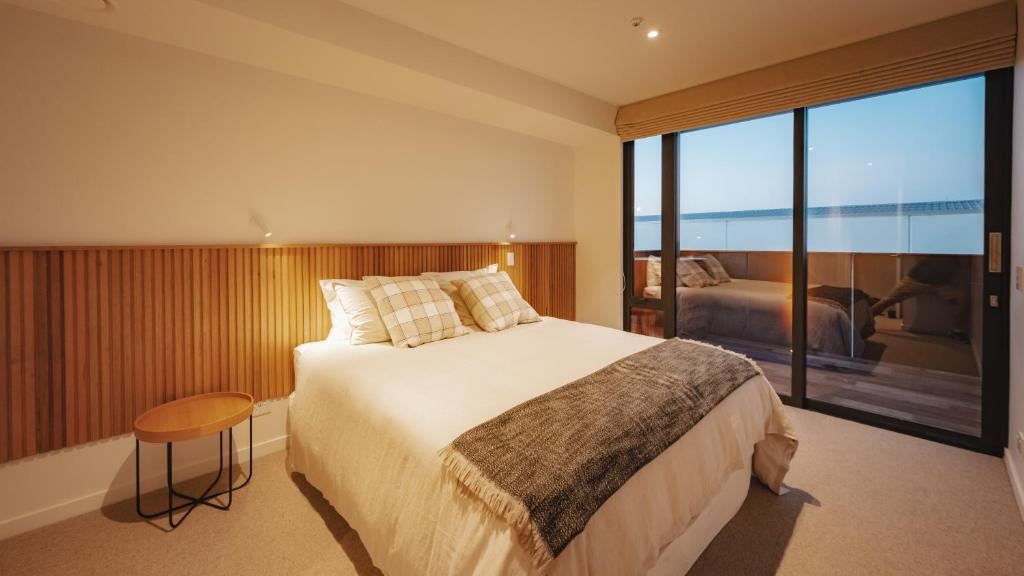 a bedroom with a large bed and a large window at Beautiful urban apartment 4 in Nelson