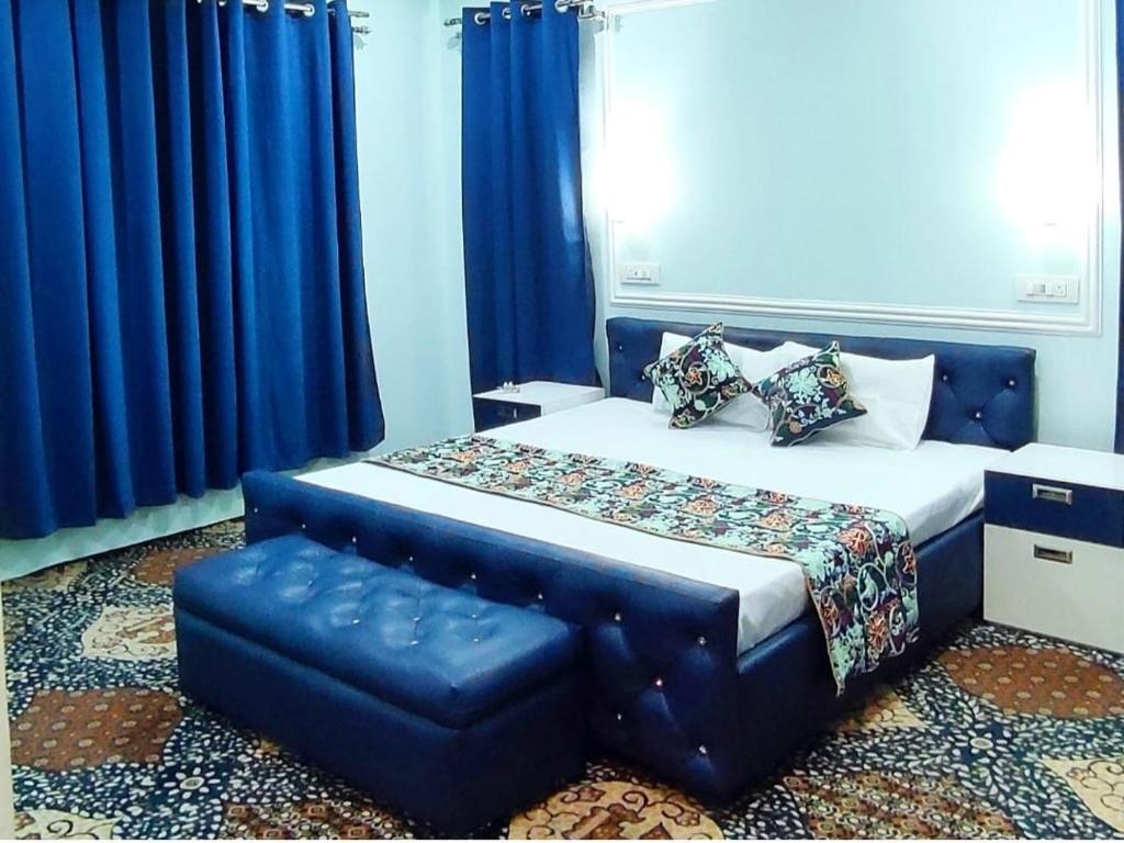 um quarto com uma cama azul e uma cadeira azul em Waneposh Residency em Srinagar