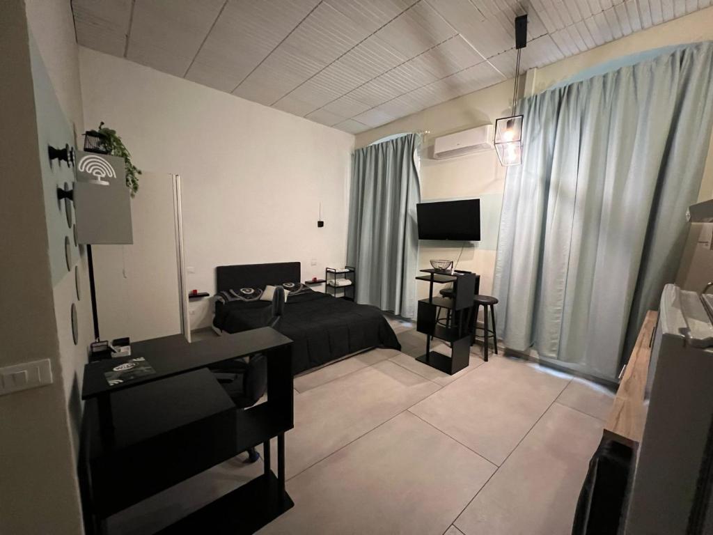 a living room with a bed and a desk and a television at Stazione centrale La Spezia 5 Terre - Luxury house in La Spezia