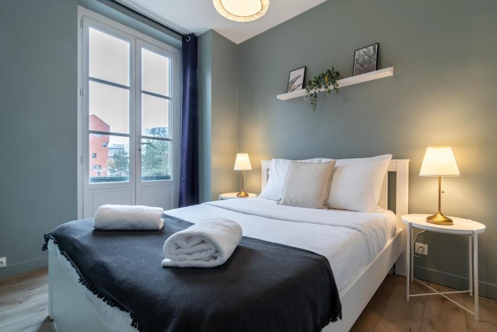 1 dormitorio con 1 cama con 2 toallas en Lille Centre - Nice and functional ap., en Lille