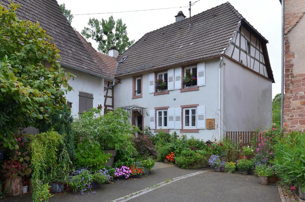 a white house with flowers in front of it at Maison d'hôtes La Renardière in Reichshoffen