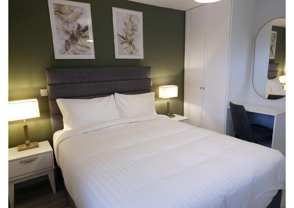 a bedroom with a large white bed and two lamps at Station Lodge in Sligo