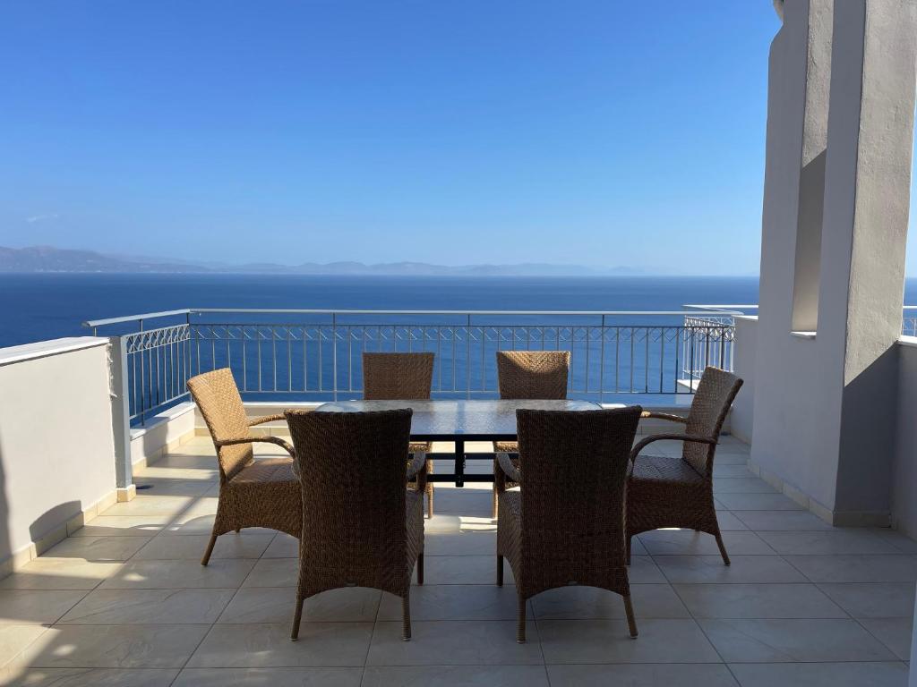 stół i krzesła na balkonie z widokiem na ocean w obiekcie Akoumaros Breeze w mieście Gythio