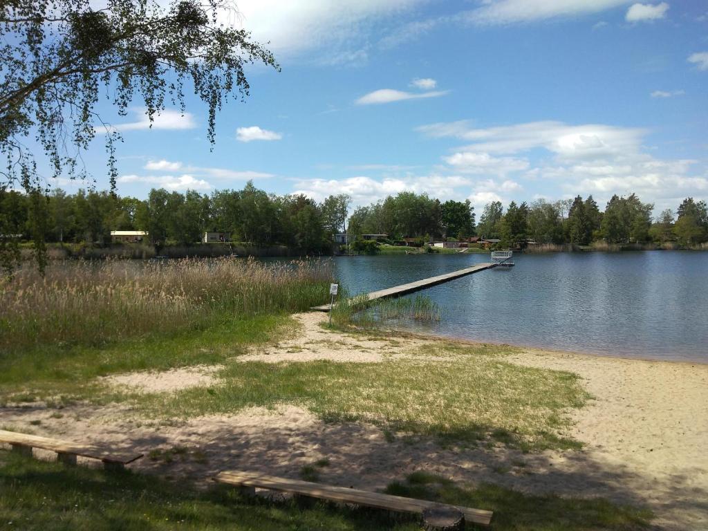 un quai sur un lac avec un bateau dans l'eau dans l'établissement NEU! See-Ferienwohnung 4, à Großmöhlau