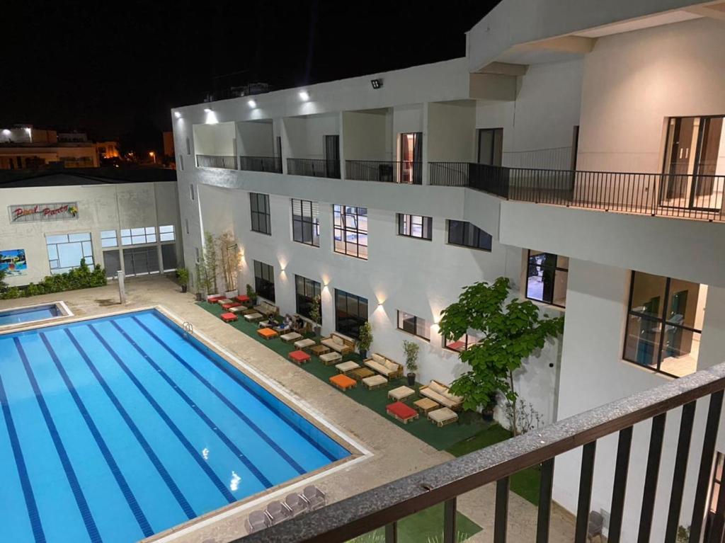 a building with a swimming pool in front of a building at Eventi Club by cité des sports adarissa in Fès
