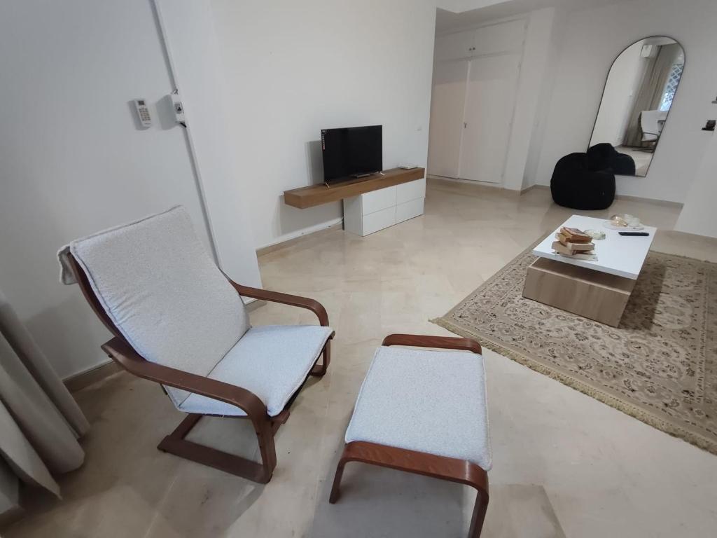 Appartement Cozy aux Berges du Lac 1 في تونس: غرفة معيشة مع كرسي وطاولة