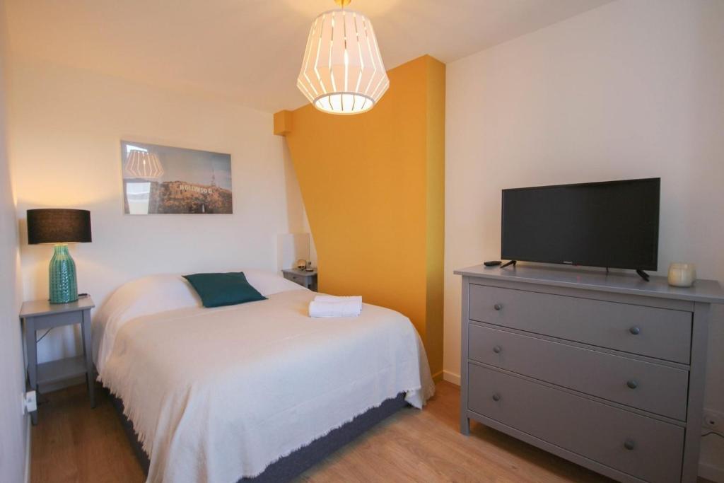 a bedroom with a bed and a television on a dresser at Lille Centre - Nice and functional ap. 2bdrm in Lille