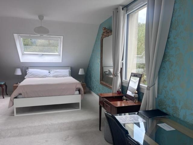 1 dormitorio con cama, espejo y ventana en Villa Omaha, en Saint-Laurent-sur-Mer