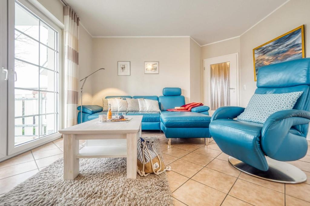 - un salon avec un canapé bleu et une table dans l'établissement Friedenstraße 7 Whg 4, à Zingst