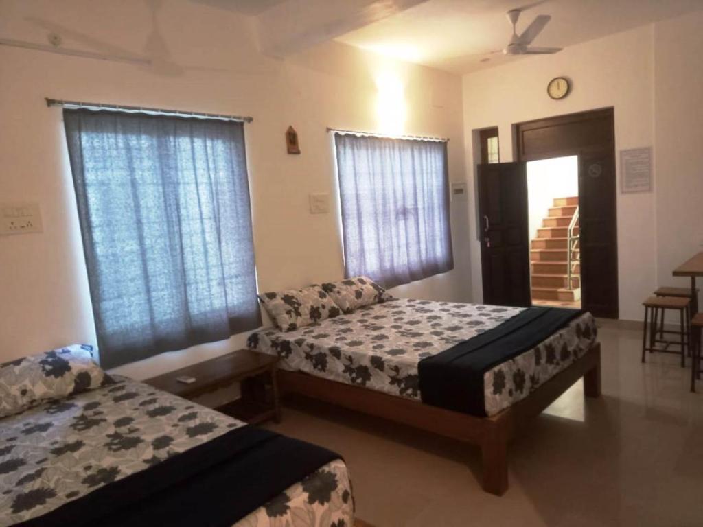 a bedroom with two beds and a couch in it at Rue Heritage inn in Puducherry