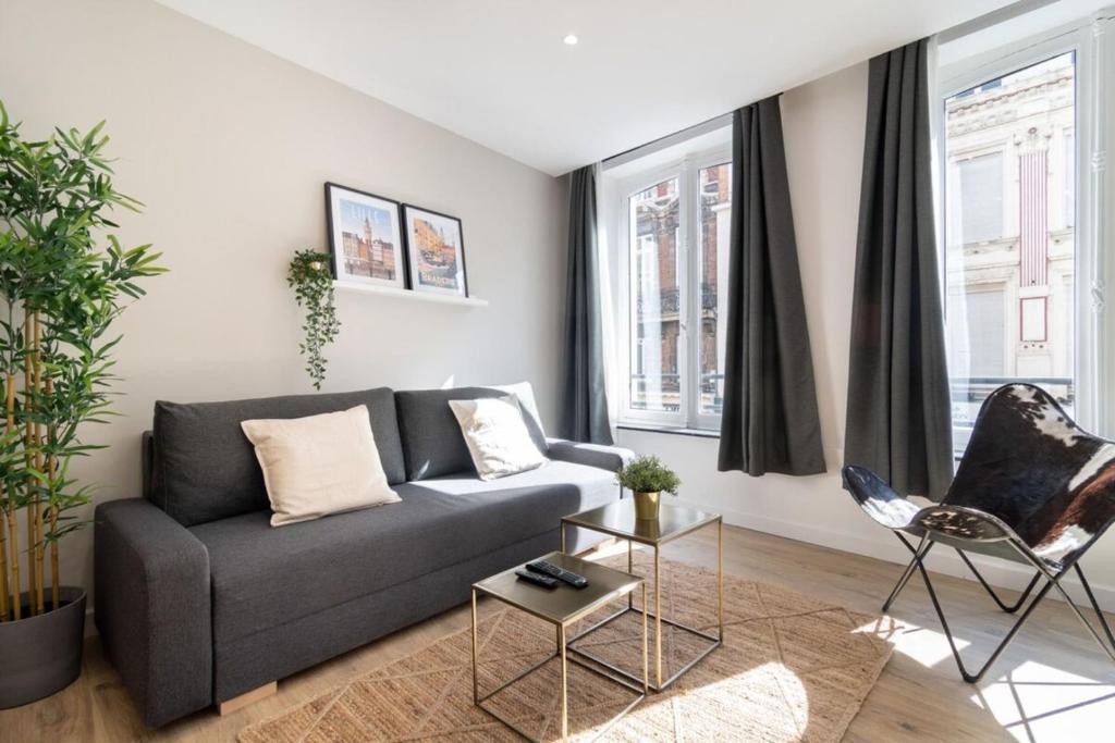 een woonkamer met een grijze bank en stoelen bij Hypercentre -Apartment in pedestrian zone in Lille