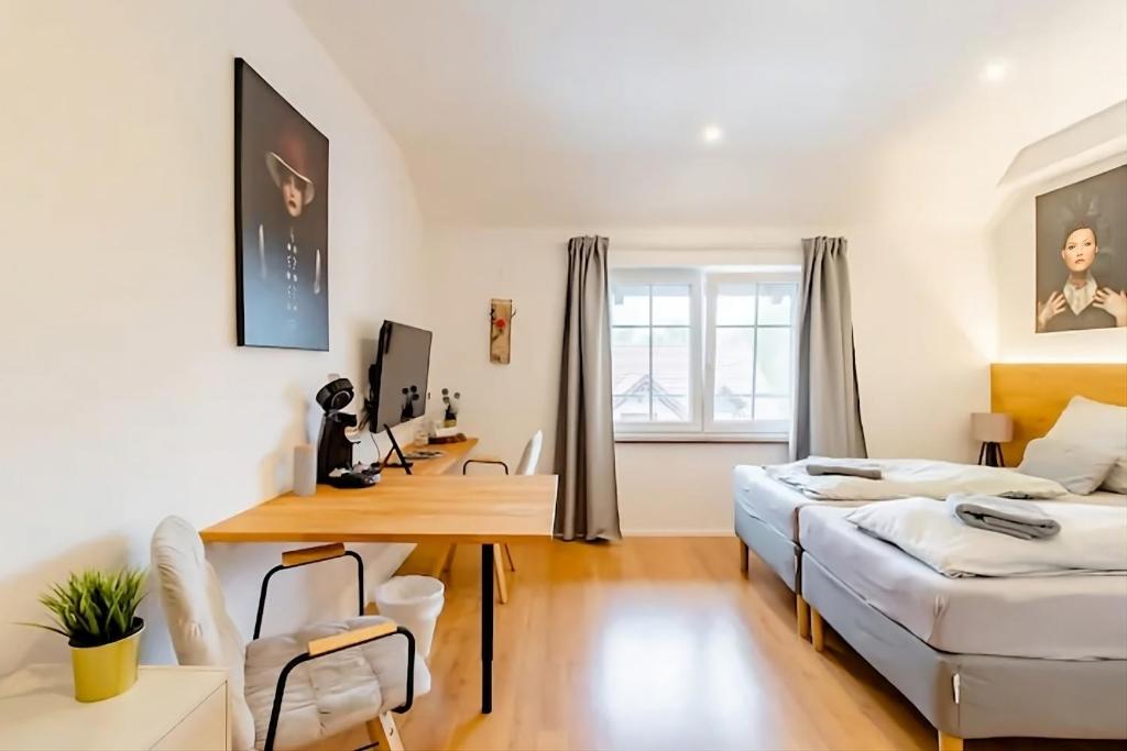 a living room with a table and a couch and a desk at Komfortables Doppelzimmer in Kehl Goldscheuer - 1A Guesthouse in Kehl am Rhein