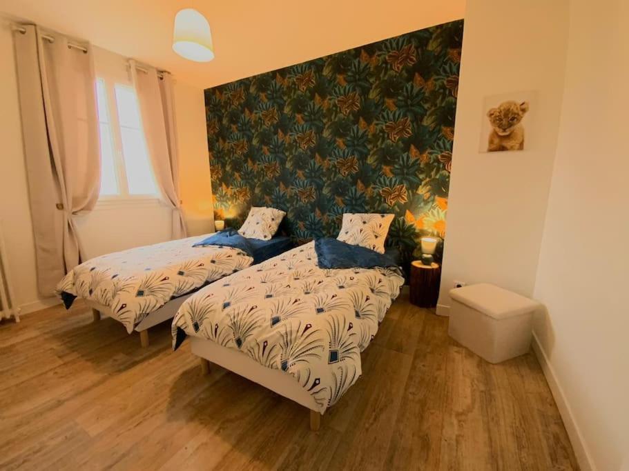 a bedroom with two beds and a wall at Chtx bel appart 3 chb parking in Châteauroux