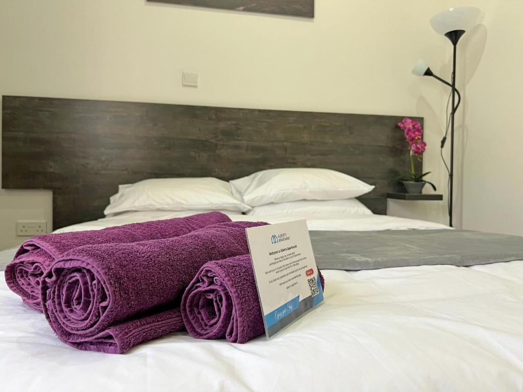 a pile of purple towels sitting on top of a bed at Apollo Rooms by Albert's Apartment in Larnaka