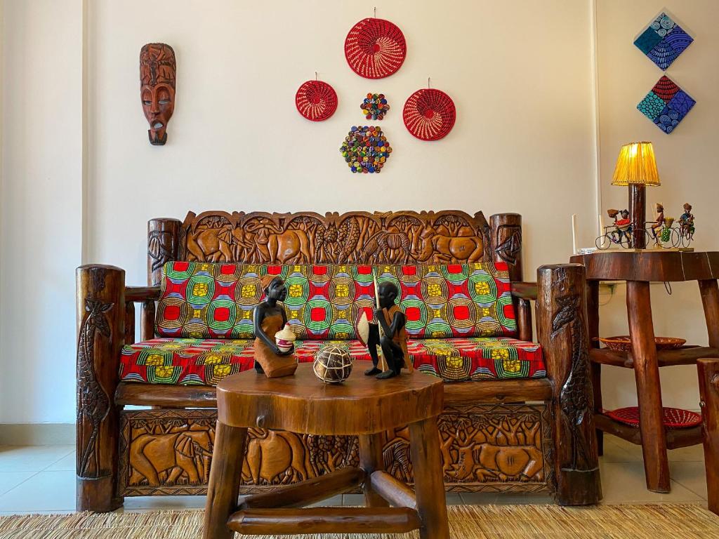 a living room with a wooden couch and a table at The Lovely Homestay in Kampala