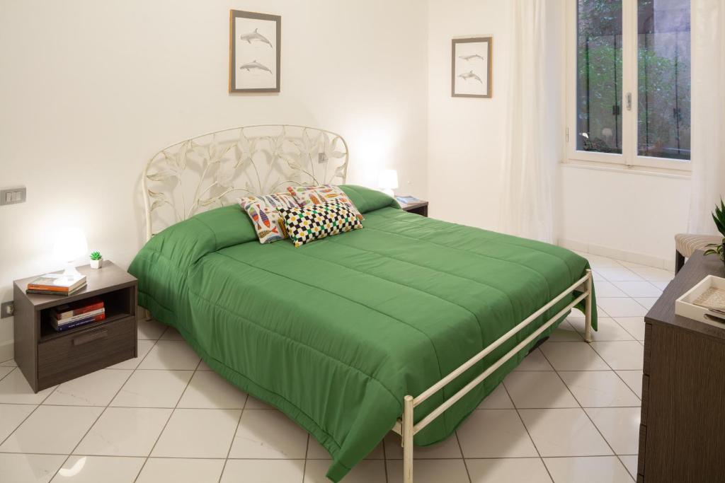 een slaapkamer met een bed met een groen dekbed bij Sirene 4 in Levanto
