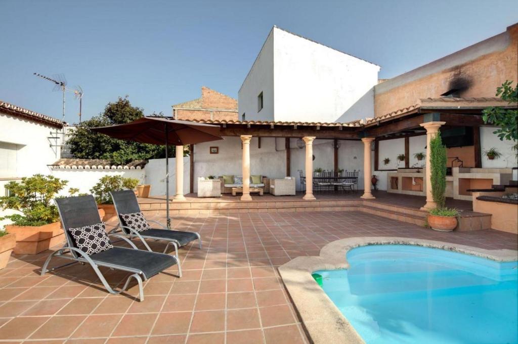 un patio con 2 sillas y una piscina en TESS Casa La Alcazaba de Serrato, en Serrato