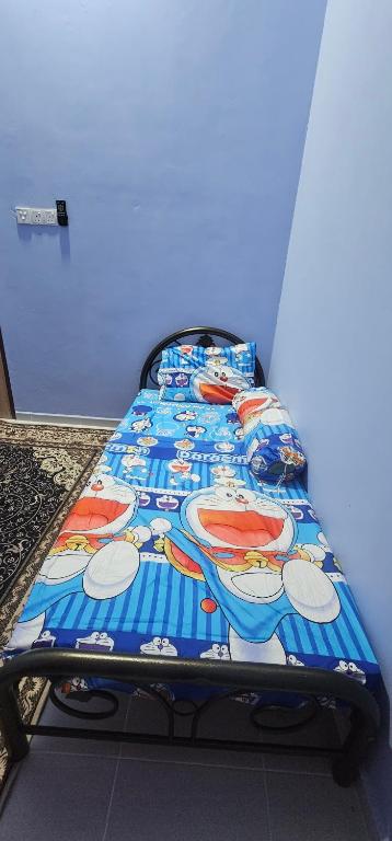 a bed with a mickey mouse blanket on it at Homestay D'Bunohan in Tumpat