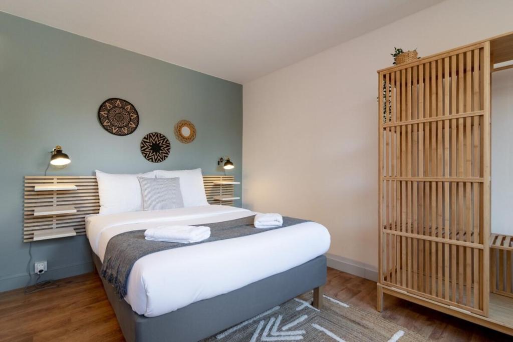 a bedroom with a bed and a crib at Grand' Place of Lille - Superb designer apartment in Lille