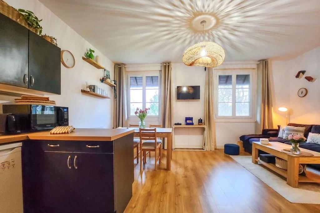 Il comprend une cuisine et un salon avec une table. dans l'établissement La Petite Sauvagère, Duplex de charme et cosy, à Villers-sur-Mer