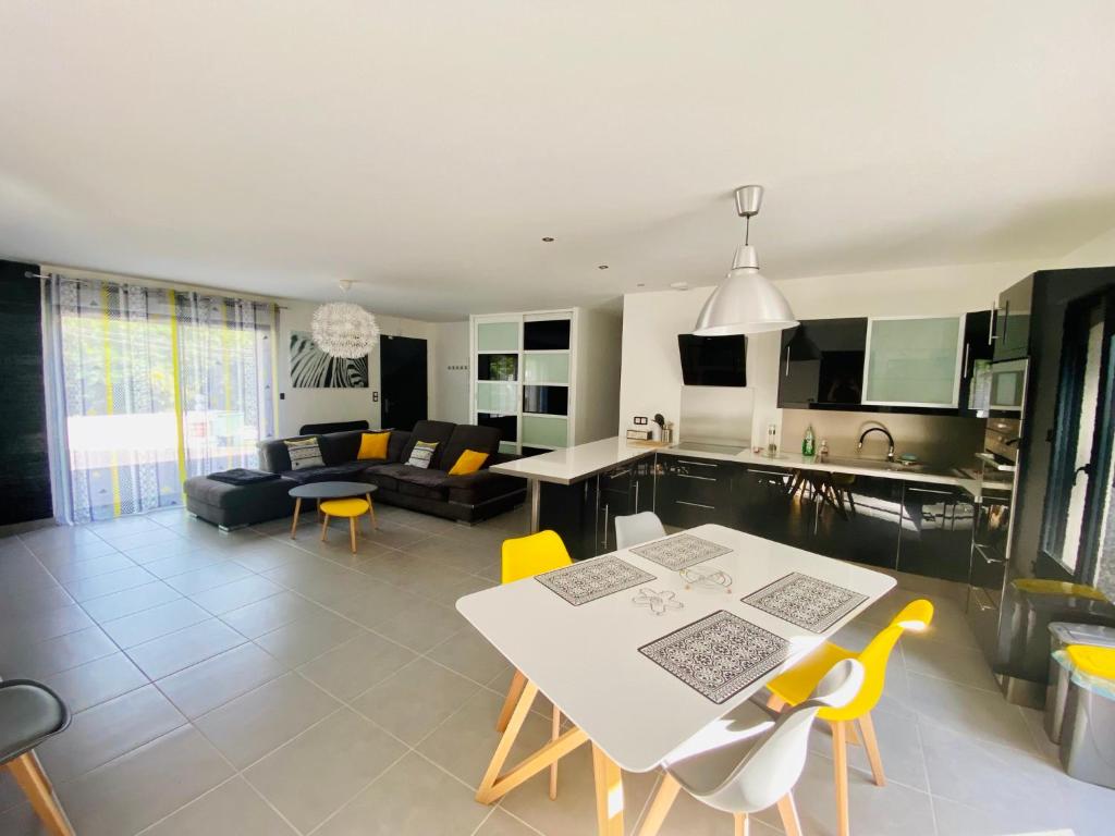 Il dispose d'une cuisine et d'un salon avec une table et des chaises jaunes. dans l'établissement Maison du Pic Épeiche, à Malemort-sur-Corrèze