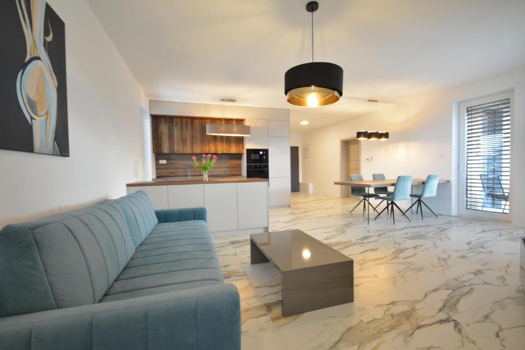 a living room and kitchen with a couch and a table at Apartments Sered in Seredʼ
