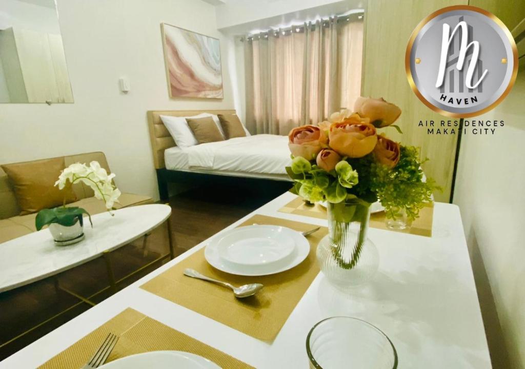 een woonkamer met een tafel met een vaas met bloemen bij M Haven in Manilla