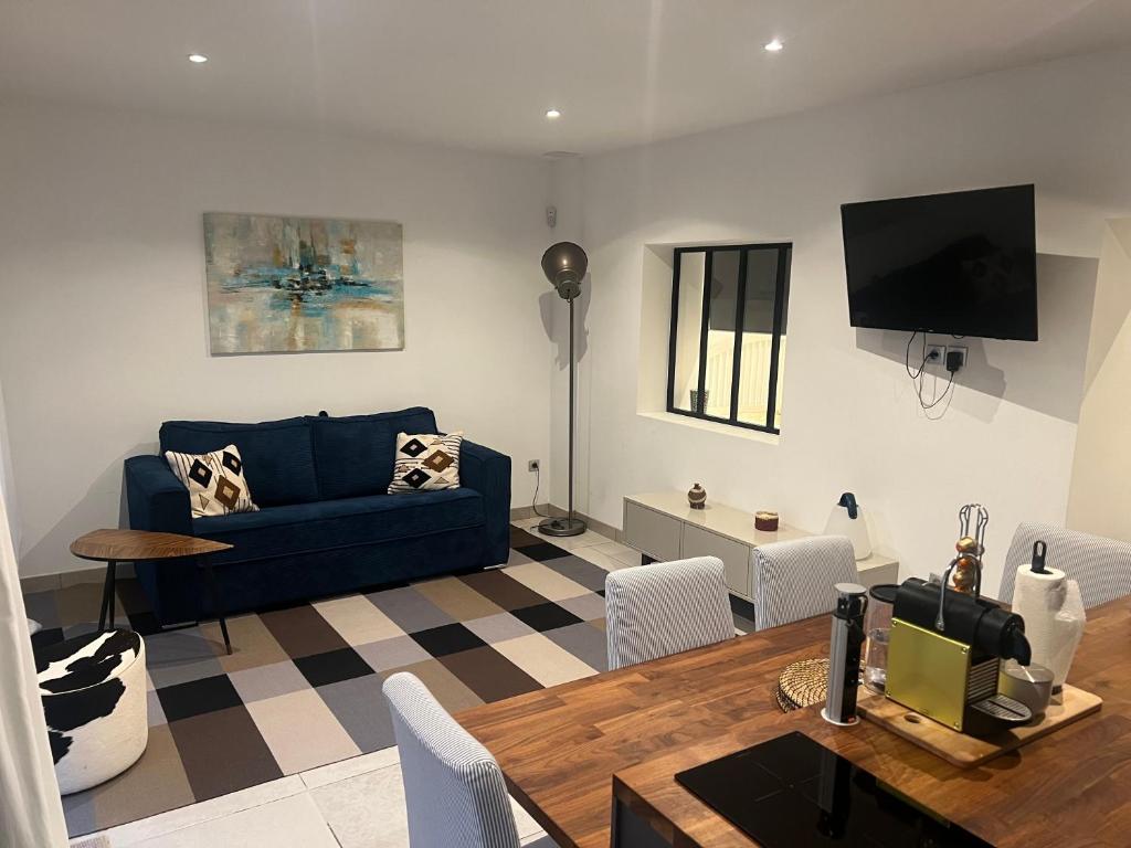 a living room with a blue couch and a table at Entre Aix et Marseille in Rognac