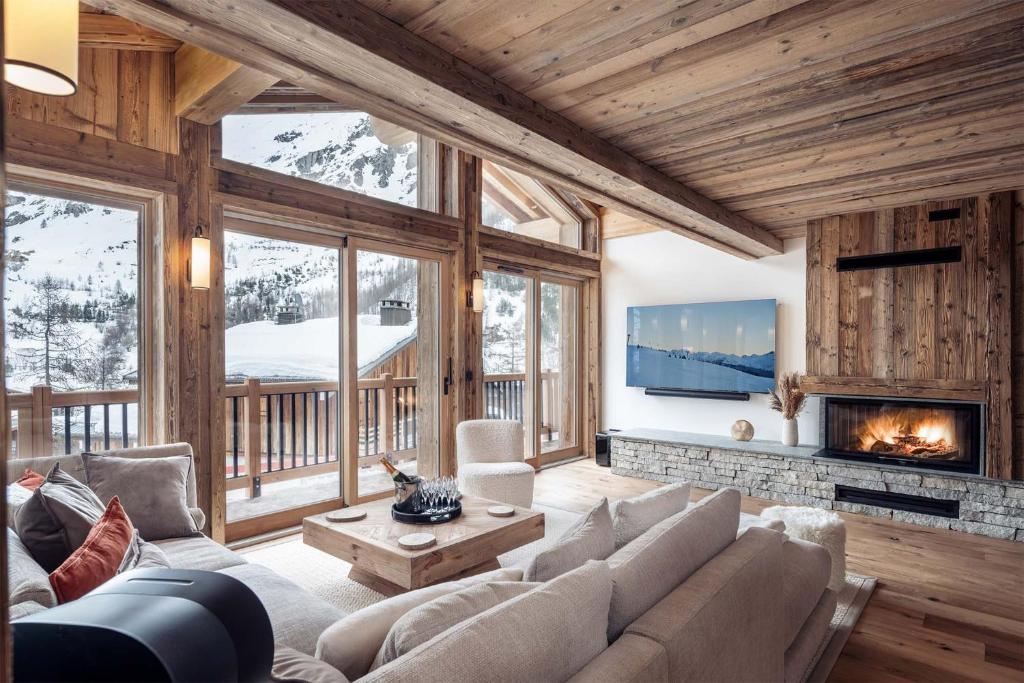 - un salon avec un canapé et une cheminée dans l'établissement Madame Vacances Chalet Arda, à Le Joseray