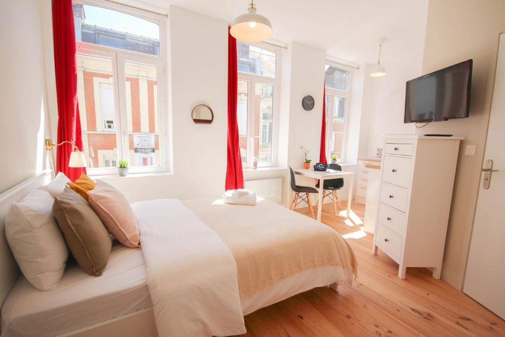 een slaapkamer met een wit bed en rode gordijnen bij Lille centre- Nice and bright equipped studio in Lille