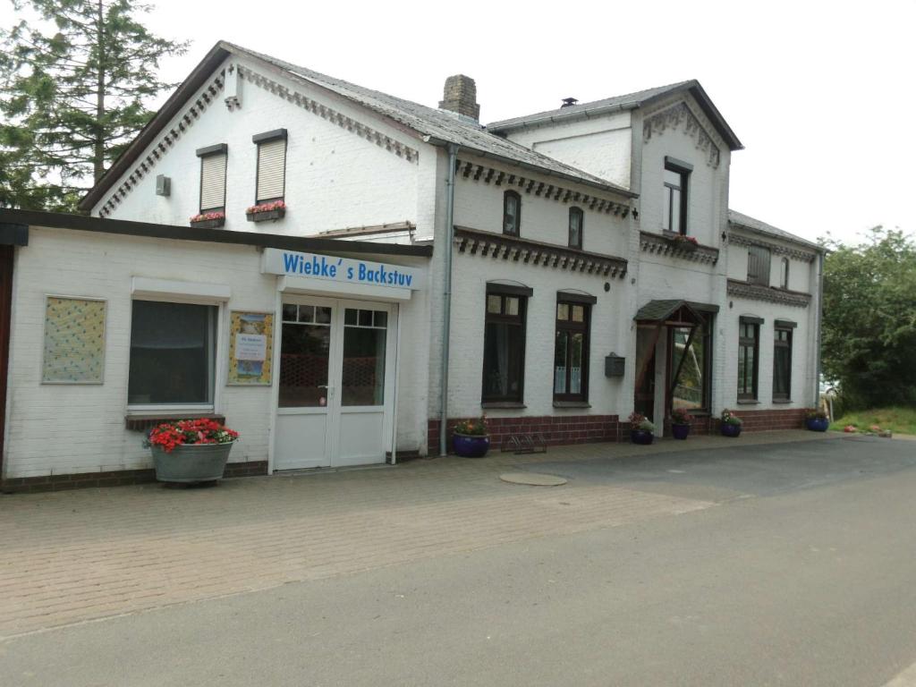 - un bâtiment blanc avec un panneau indiquant une cuisine à gaufres dans l'établissement Ferienwohnung 'ole Bäckerei', à Delve