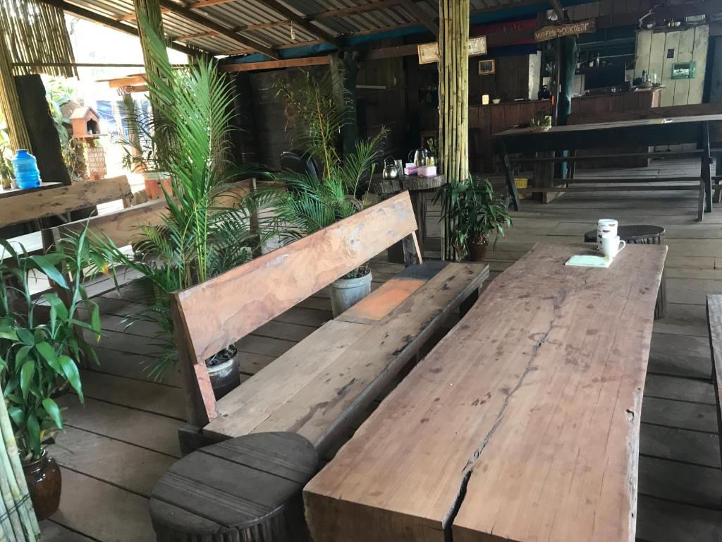 a wooden bench sitting on a patio with plants at New Happy Elephant Bungalows 