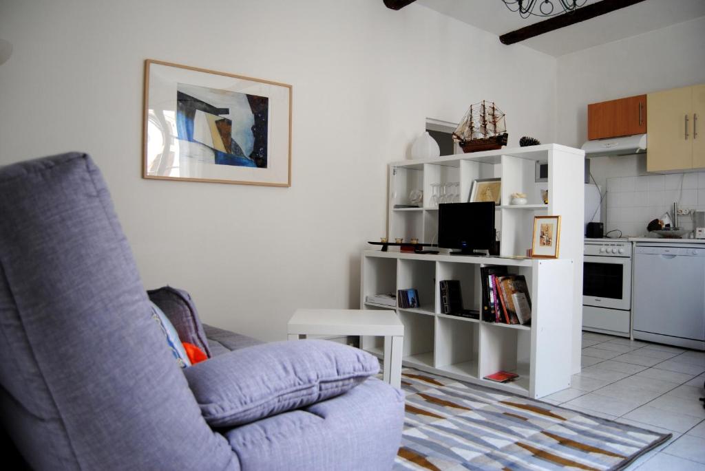 a living room with a couch and a kitchen at Pézenas appartement coeur historique in Pézenas