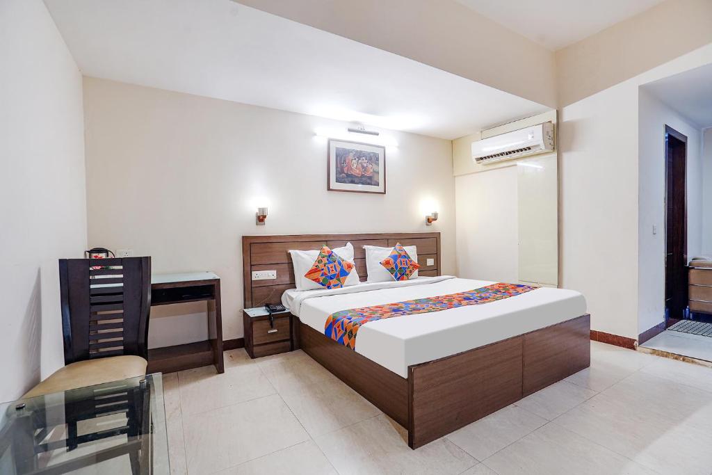 a bedroom with a bed and a desk in it at FabHotel Amman in Agra