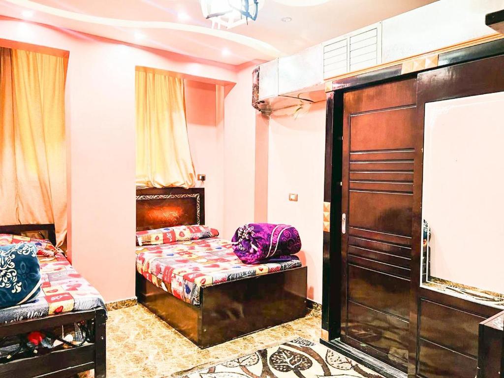een kamer met 2 bedden en een bank. bij شقة مميزة بجوار كورنيش النيل اسوان - عائلات فقط in Aswan