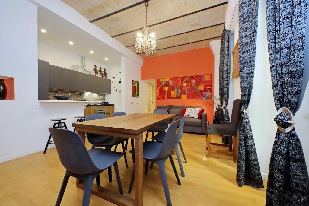 a dining room and kitchen with a wooden table and chairs at Apartment Vespucci in Rome
