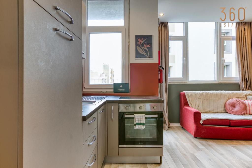 una cucina con divano rosso e sedia rossa di Modern Paceville Suites with WIFI & AC by 360 Estates a Paceville