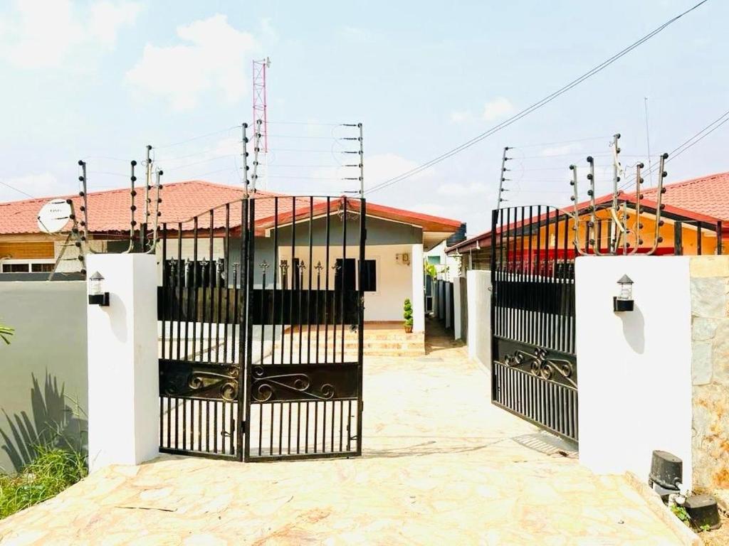 ein schwarzes Tor vor einem Haus in der Unterkunft Wyndham Villa in Ogbojo